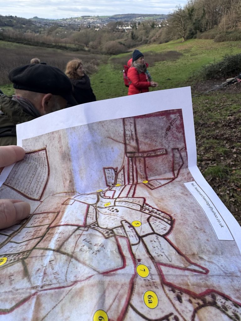 Photocopy of 1690’s map of Heavens valley area held up so it aligns with view down the valley