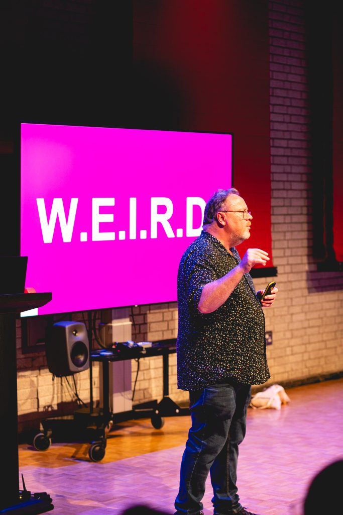 Alastair in front of slide saying WEIRD