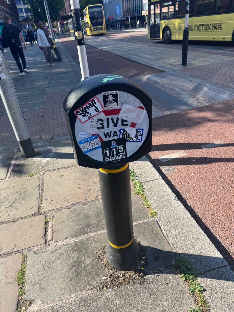 Give Way sign aimed at cyclists obscured by stickers